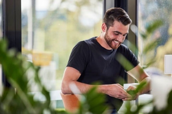 A young man on his phone and smilling