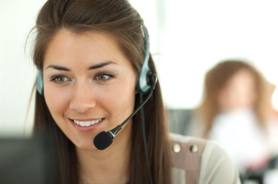 A Student enrolment advisor on a call with her headphones on and smilling
