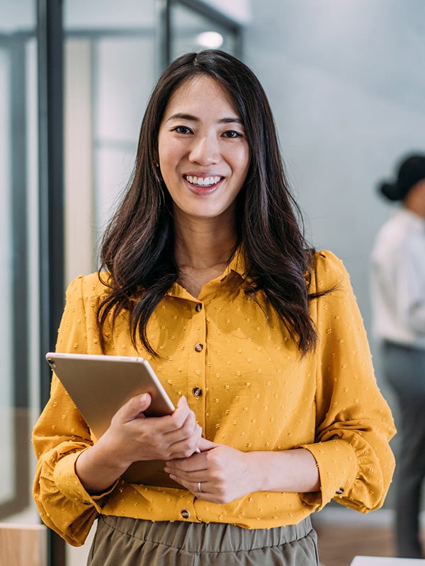 One UC online student reading a book and smiling