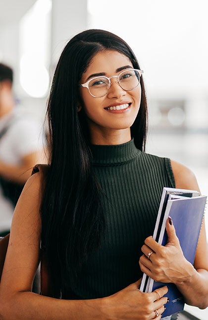 One UC online student reading a book and smiling