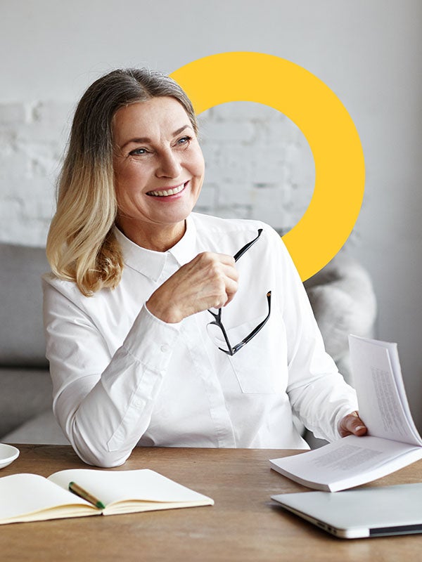 One UC online student reading a book and smiling