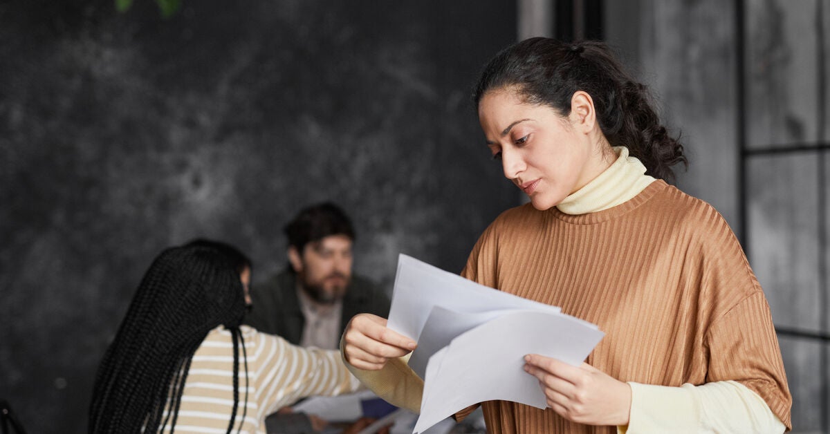 Woman looking at a paper reading about basic counselling skills