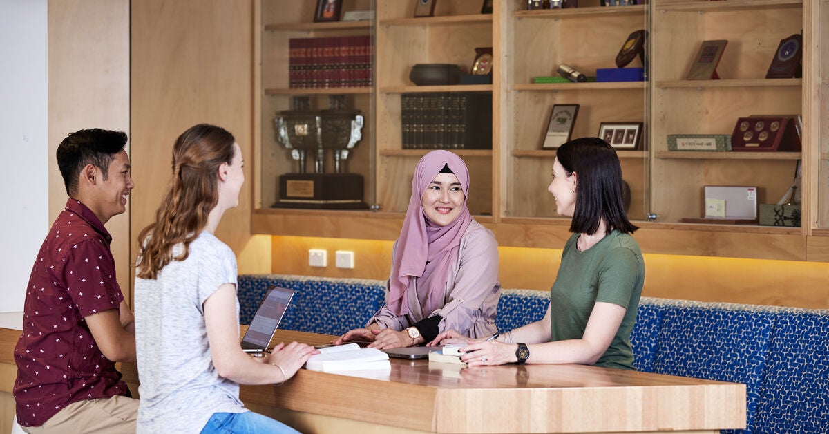 Four adults sitting around a table discussing basic counselling skills