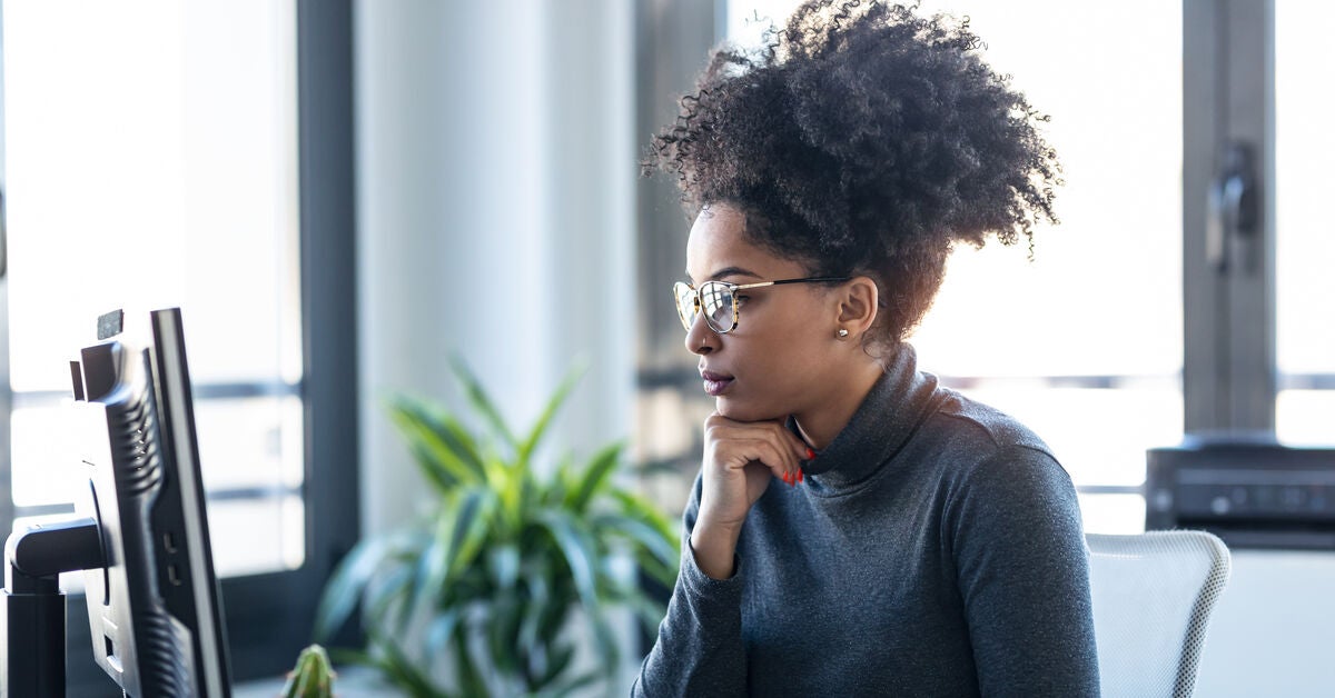 A woman staring at her computer screen thinking about what do you need to study to become a counsellor