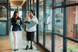 A school principal walks confidently through a school hallway, symbolising educational leadership and career growth.